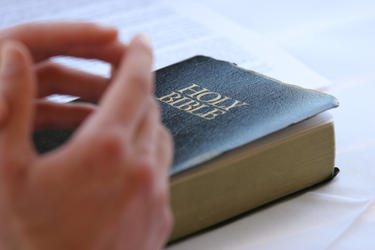 Hand on top of a Holy Bible.