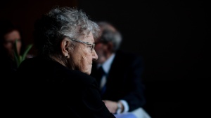 A elderly woman sitting by herself. 