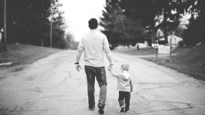 A dad walking with his young child.