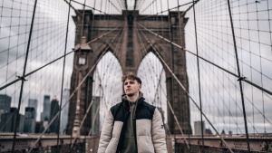 A man walking on the Brooklyn Bridge.