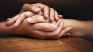 Two people's hands touching and showing comfort.