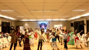 a group of teenagers wearing traditional costumes and dancing