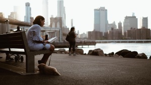 A woman sitting on a bench reading.