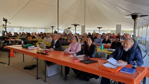 people sitting at services under a big tent