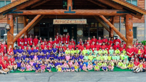 a large group of people, mostly children, with matching shirts standing outside