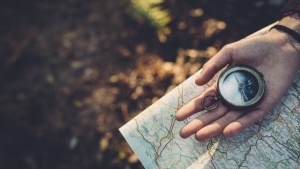 A person holding a compass and a map.