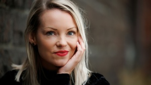 a young woman wearing a black dress looking sideways