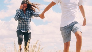 a couple walking through the grass holding hands