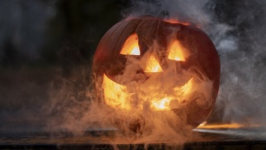 a jack-o-lantern that is glowing with smoke coming out from inside