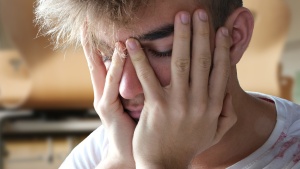 a young man with his head in his hands