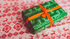 A green present wrapped with red bow.