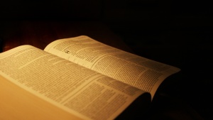 An open Bible in a dark room.