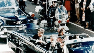 President John F. Kennedy  riding in a motorcade in Dallas, Texas.