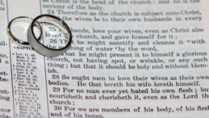 Wedding rings on top of Bible scripture - Ephesians 5:22-21