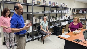 four people inside a building with shelves of literature