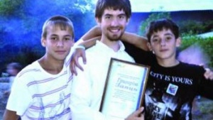 Gregory Zajac with two campers celebrating at the end of a successful camp.