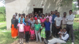 A group shot of the congregation in Mapoko. Behind them is the church building the brethern built.