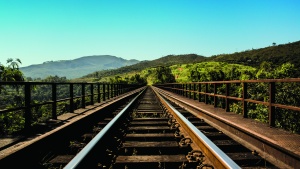 Photo of train tracks disappearing forward into the distant mountains.