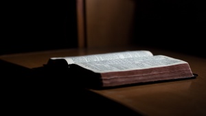 A an open Bible on a table.