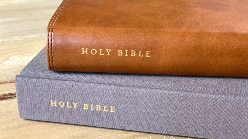 Two Bibles stacked on a table