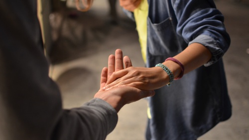 two people standing with one person's hand in the other's outstretched palm