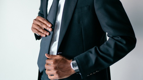 a man wearing a suit adjusting his tie