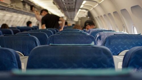 rows of blue seats inside an airplane