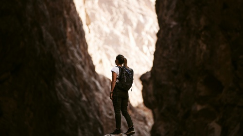 a woman standing on a rock surrounded on either side by a rockface