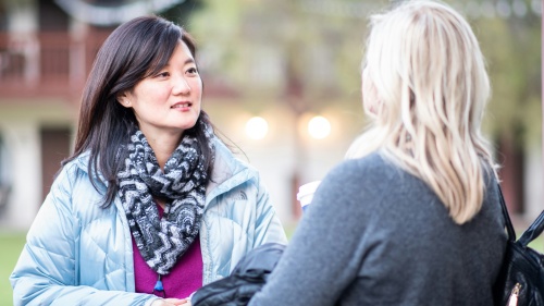 two women dressed in warm clothes having a conversation