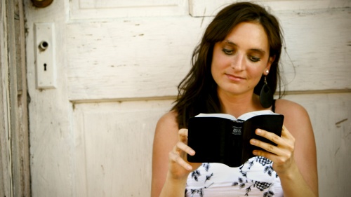 A young woman reading a Bible.