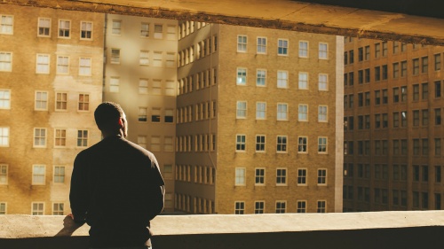 A man looking buildings in a large city.