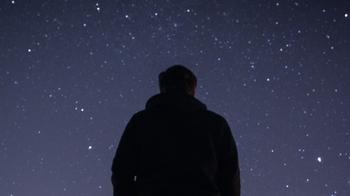 A young person looking up at the stars.