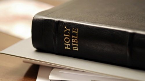 A Bible laying on top of papers.