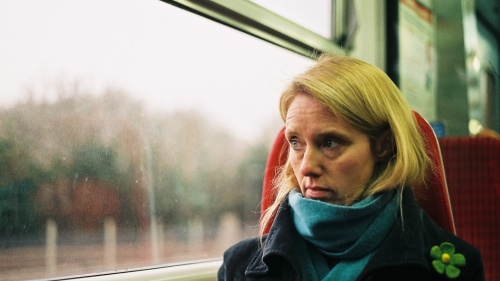 A woman sitting in a train looking out the window.