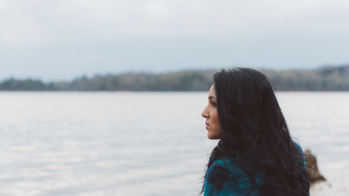 A woman looking out over a lake.