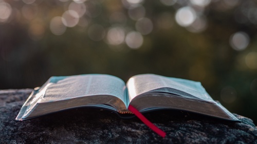 An open Bible laying on a table.