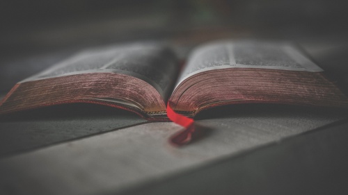 An open Bible laying on a table.