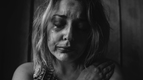 A woman crying photographed in grayscale