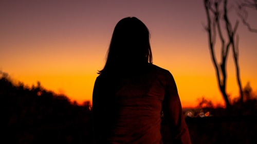 A woman watching the sunset.