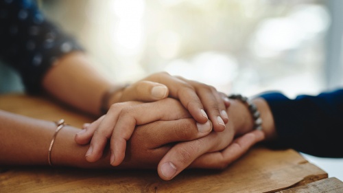 Comforting hands of two people.