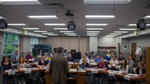 Dr. Frank Dunkle stands at the lectern facing a group of students.