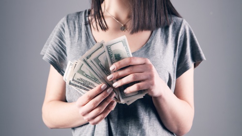 a woman holding one-hundred dollar notes