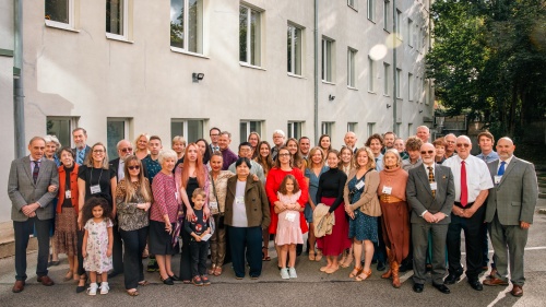 a group of people outdoors in front of a white building