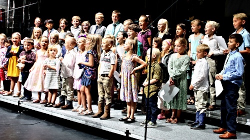 a large children's choir standing on a stage