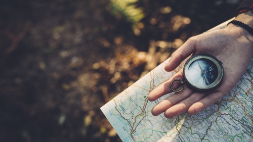 A person holding a compass and a map.