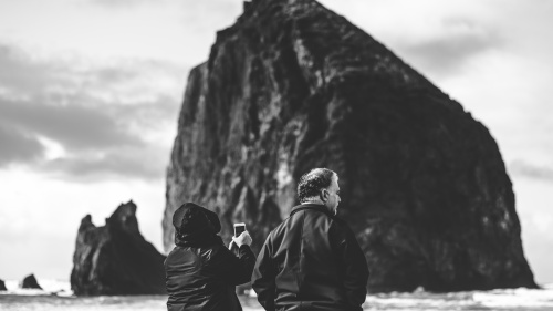 A couple taking photos at the beach.