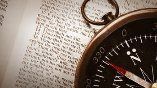 Compass on top of Bible - Showing the Ten Commandments