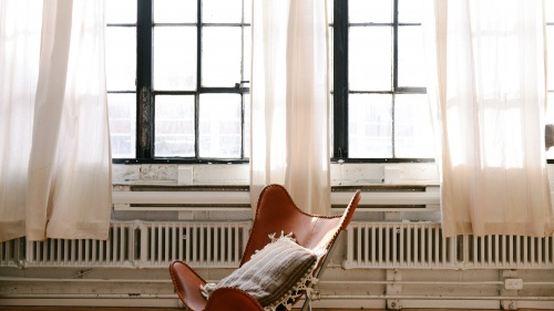 Chair in front of two big windows.