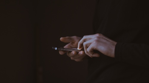 A person using a smartphone in the dark.