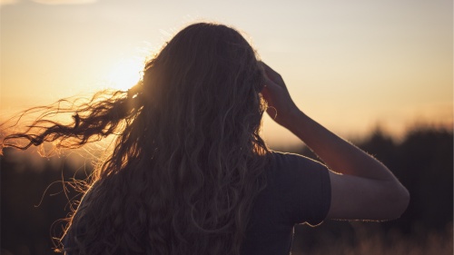 A young woman with her hair blowing in the wind.